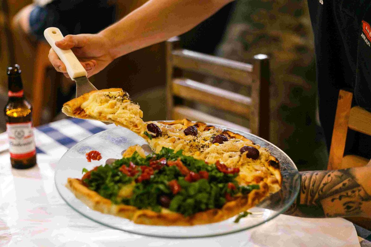 Pizzaiolo servindo uma fatia de pizza